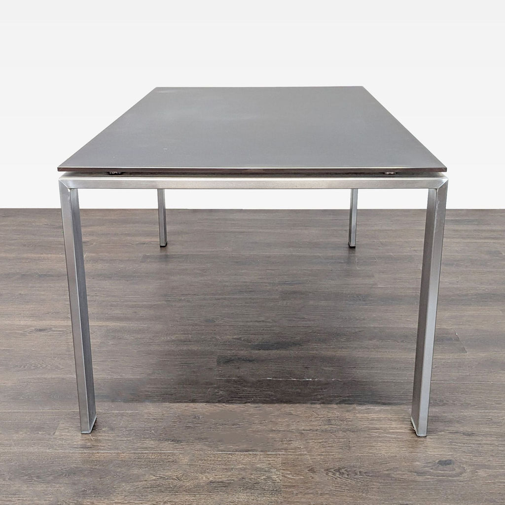 3. Minimalist Room & Board table with a durable black glass top and silver metal base, ideal for any space.