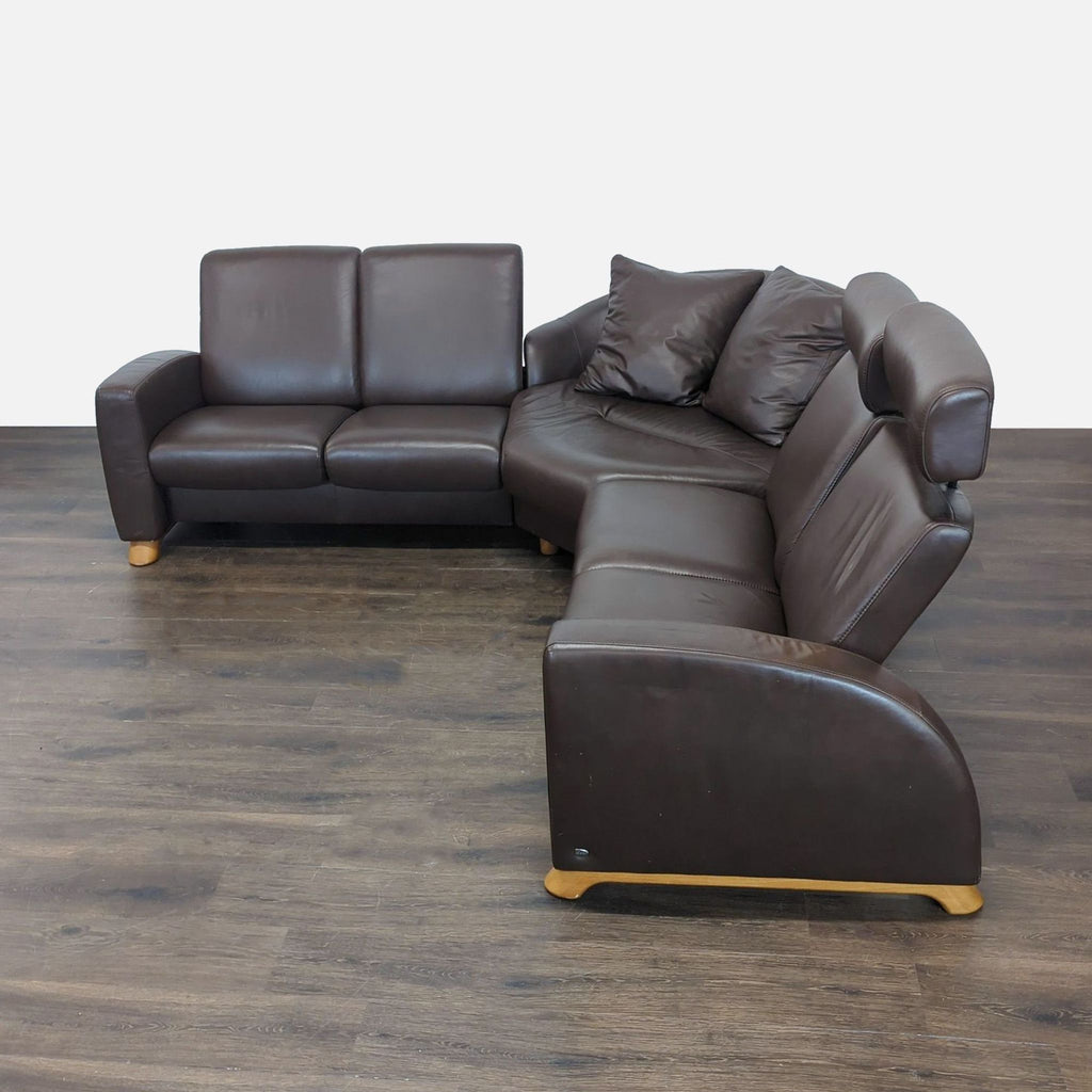 1. Brown leather Stressless sectional with L-shape, wood legs, and matching cushions on a wooden floor.  