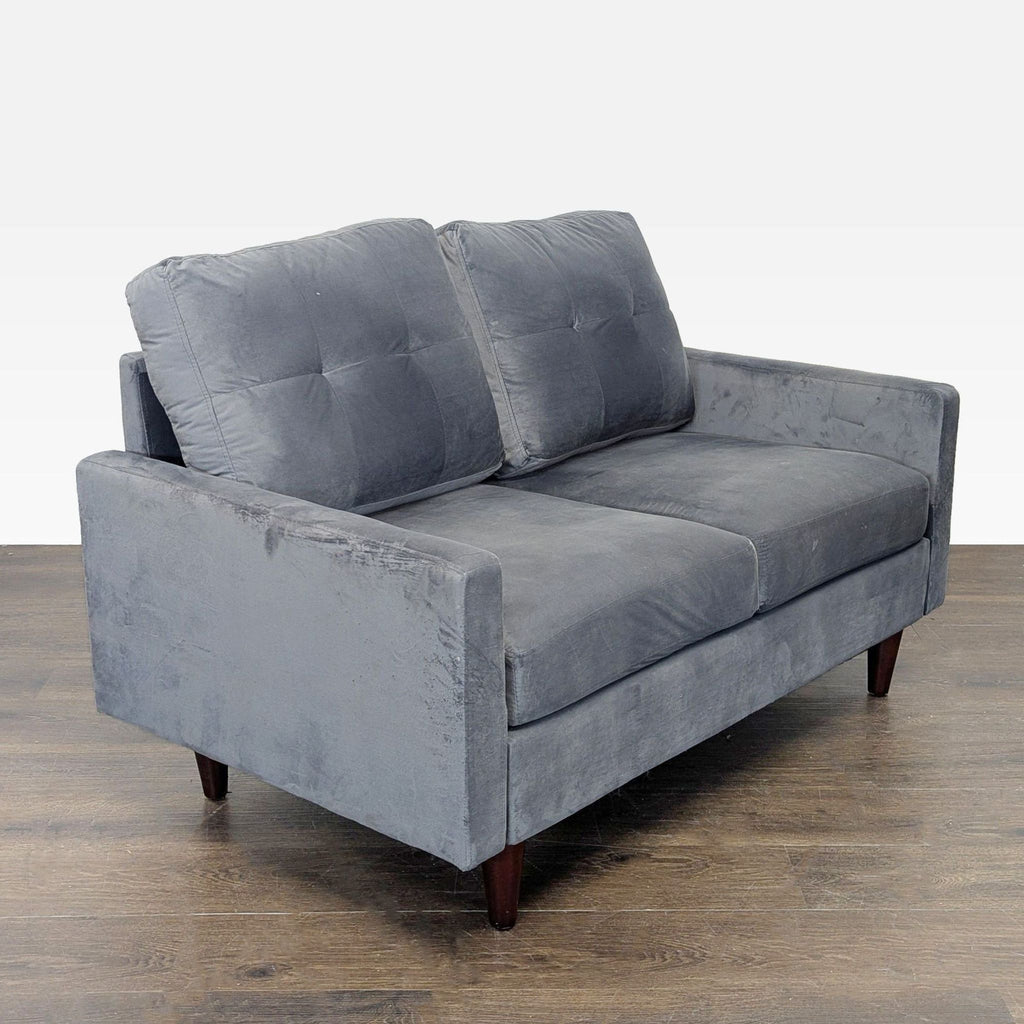 Modern gray loveseat with plush, tufted velvet fabric and sturdy wooden legs, ideal for small spaces.