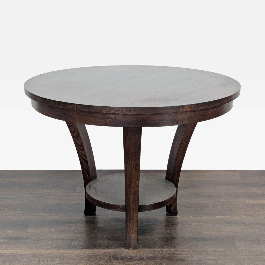 1. Round dark wood dining table with curved legs and lower shelf, set on hardwood flooring.