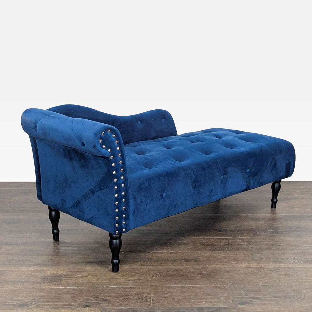 2. Elegant blue velvet chaise, featuring a tufted seat, curved backrest, silver studs, and classic wooden legs.