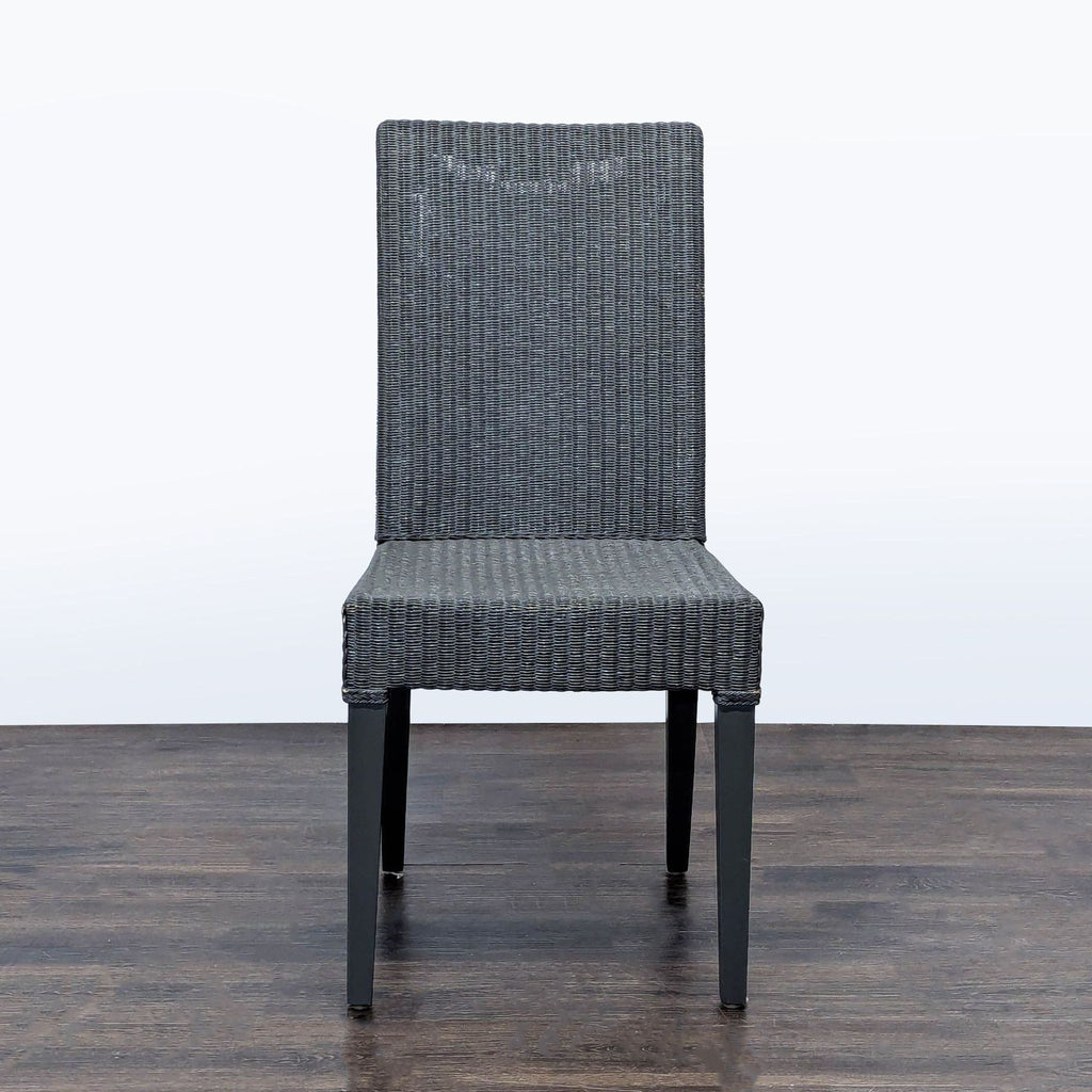 Sculptural woven dining chair by JANUS et Cie with wicker-look seat and wooden legs, perfect for dining rooms.  