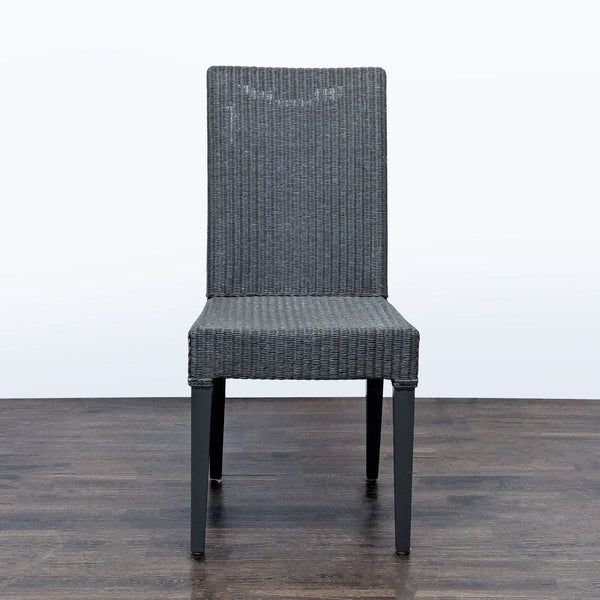 Sculptural woven dining chair by JANUS et Cie with wicker-look seat and wooden legs, perfect for dining rooms.  