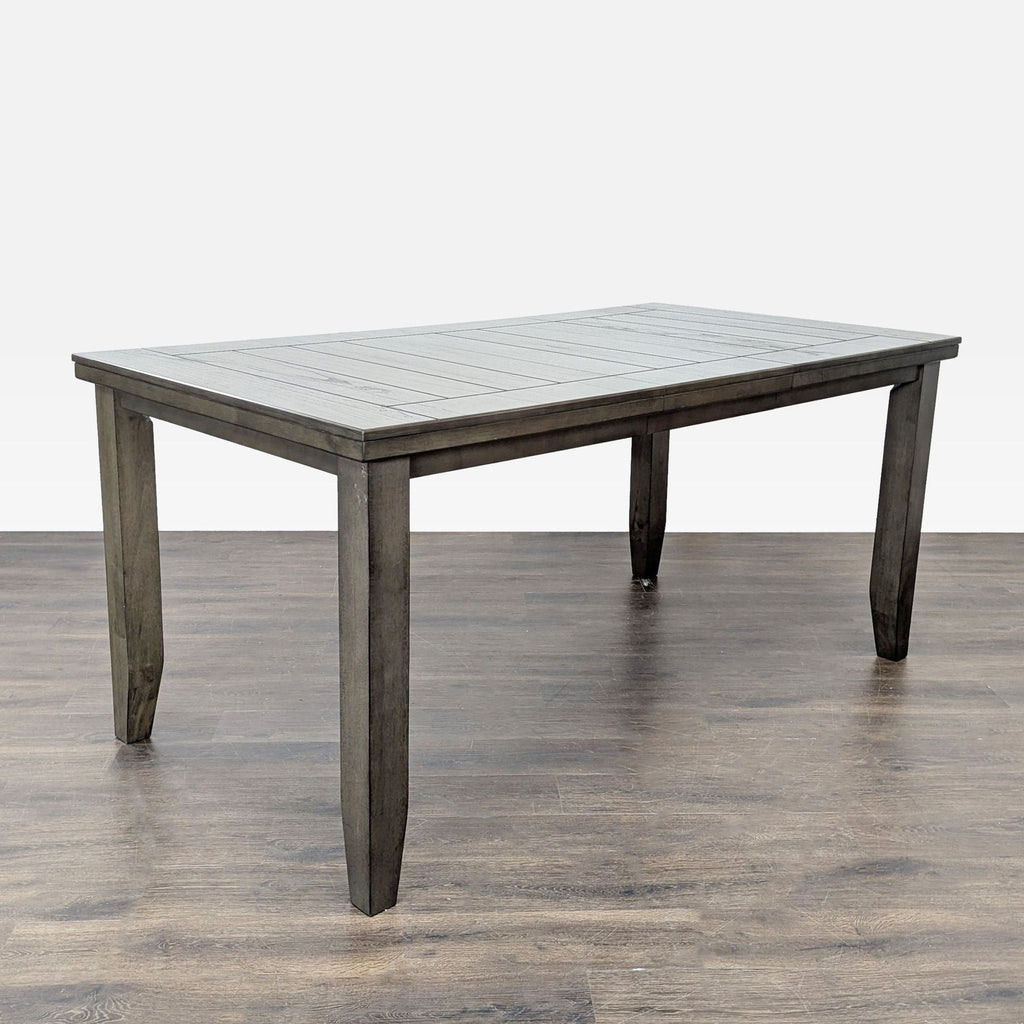 2. Angled view of a gray wooden Crown Mark dining table, includes one leaf for added length.  