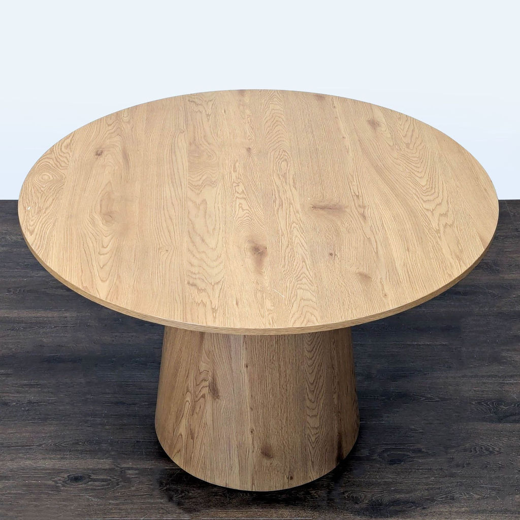3. Overhead view of a round wooden dining table highlighting its natural grain and single pedestal base.