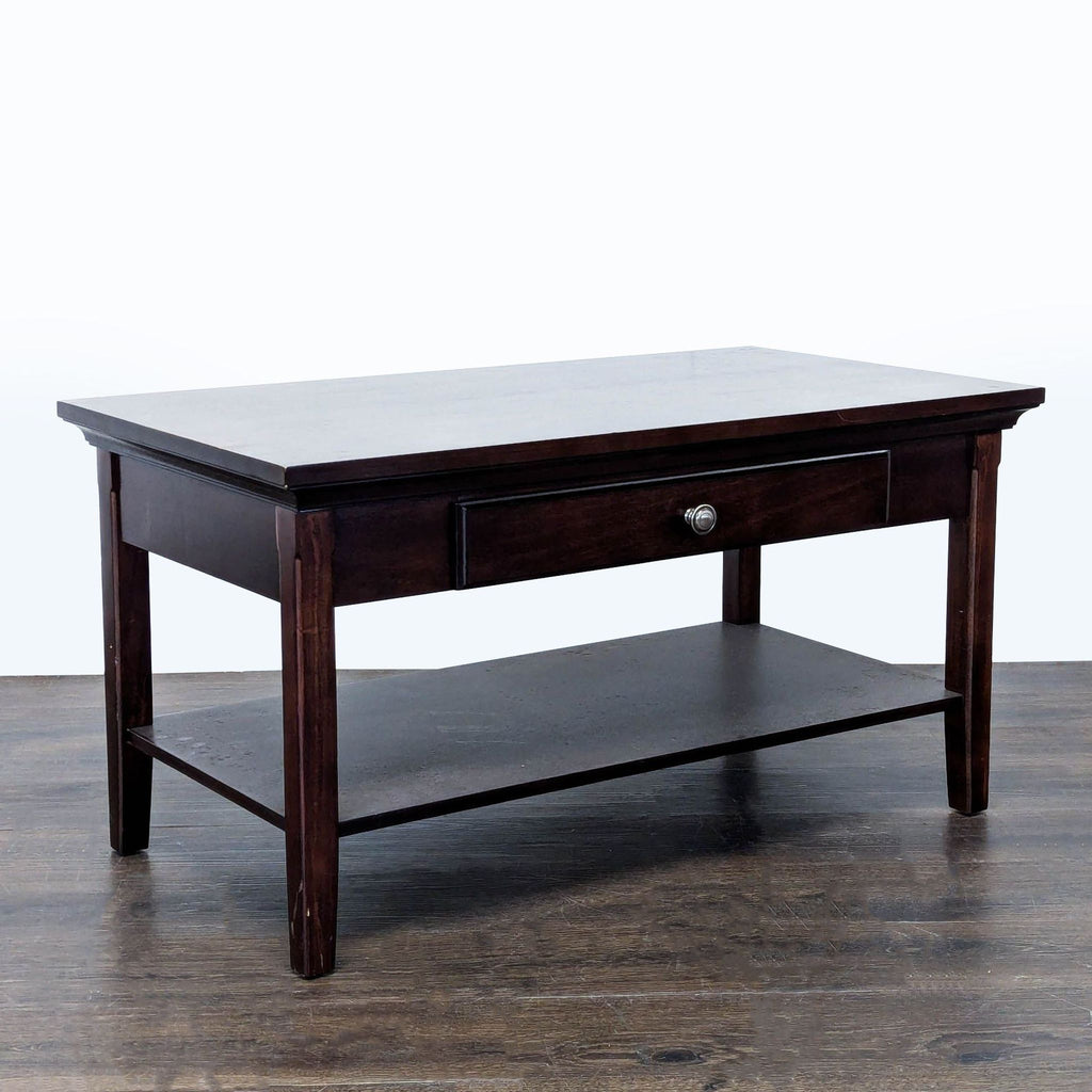 3. Side perspective of a dark wood coffee table featuring a central drawer and a lower storage shelf.