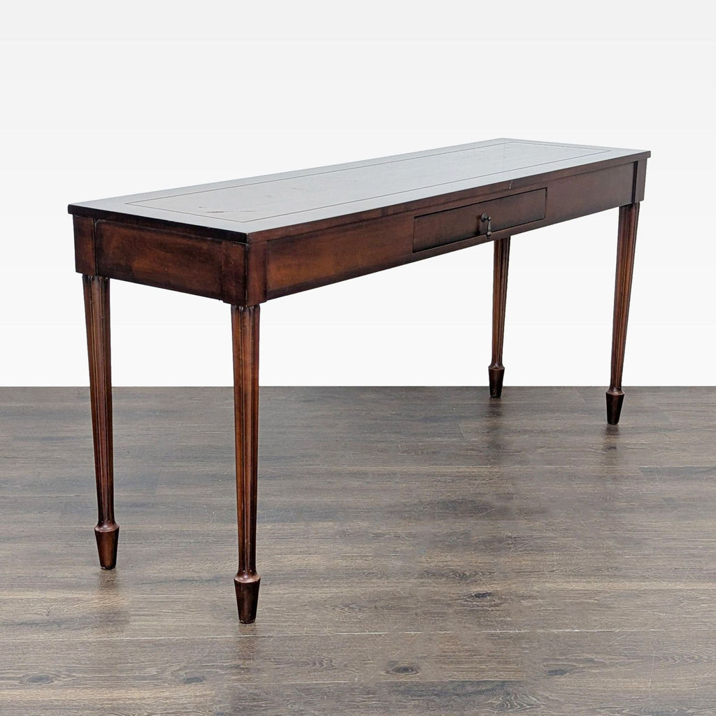 3. Elegant wooden console table with fluted legs and a center drawer, positioned against a plain background.