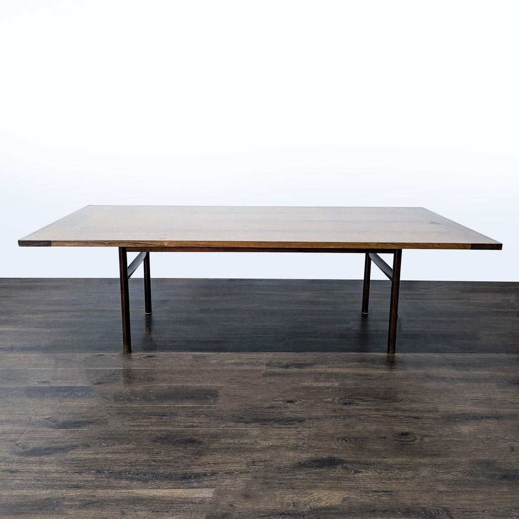 1. Rectangular wooden dining table with minimalist dark legs, placed on a dark floor against a plain background.  
