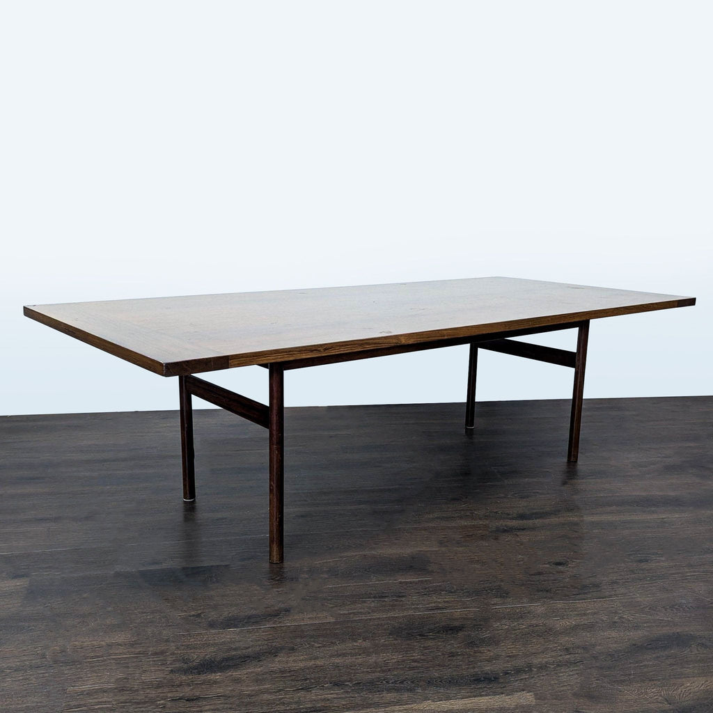 2. Sleek wooden dining table with a flat top and slim legs, shown at an angle on a wooden floor.  