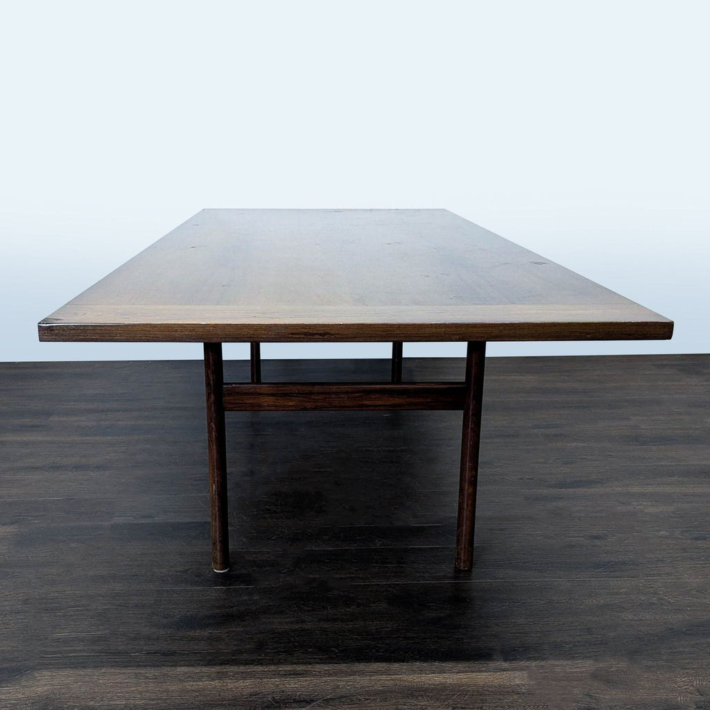 3. Dining table with a wide, rectangular wooden surface and sturdy legs, photographed from the head-on view.