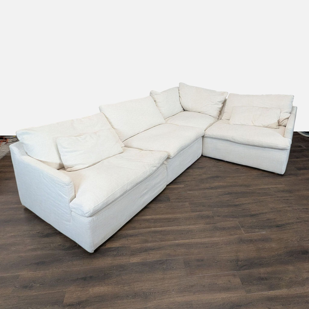 Spacious L-shaped sectional sofa by Restoration Hardware, featuring soft cream fabric and sturdy build.