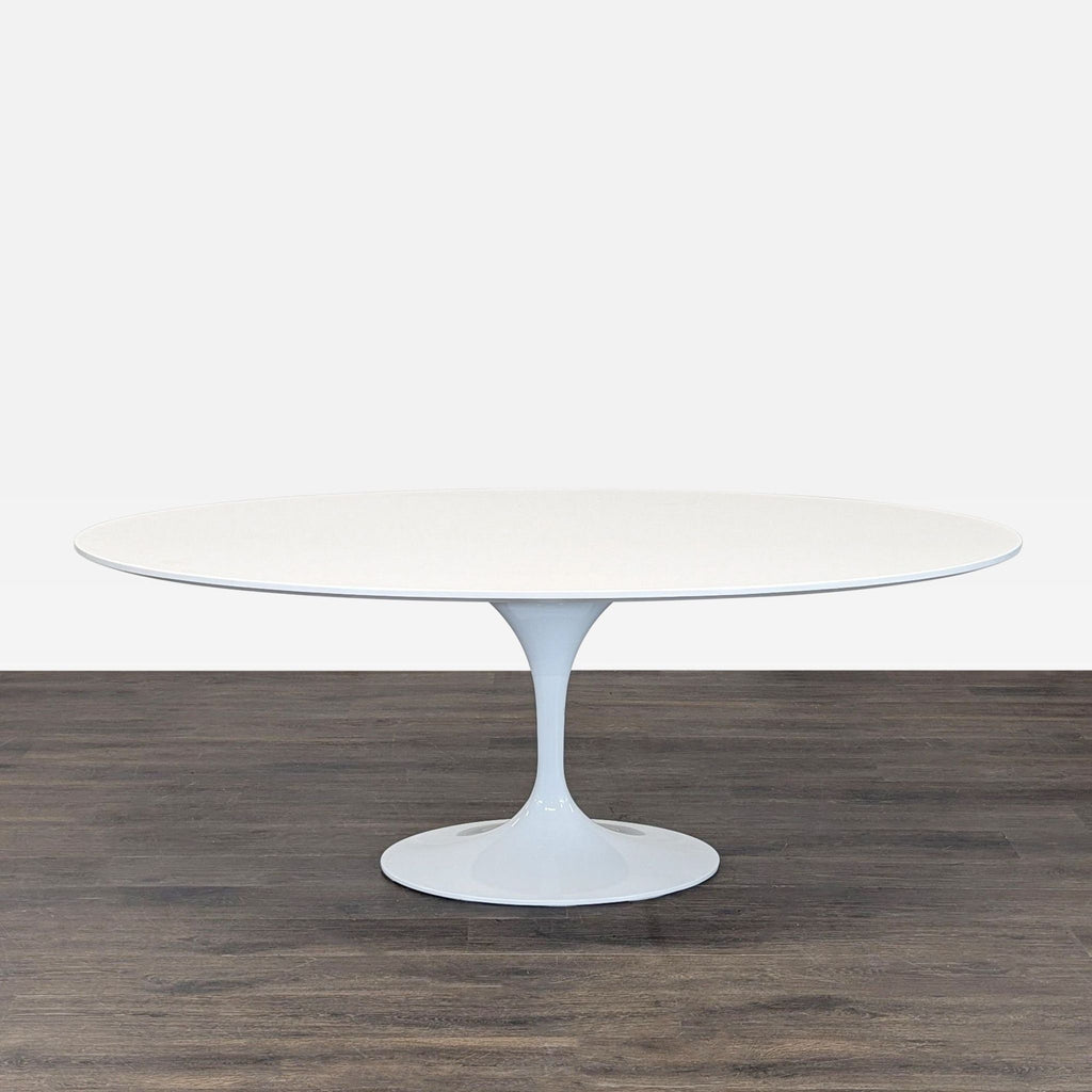 A modern white tulip dining table with a single pedestal base, featuring a minimalist mid-century design.