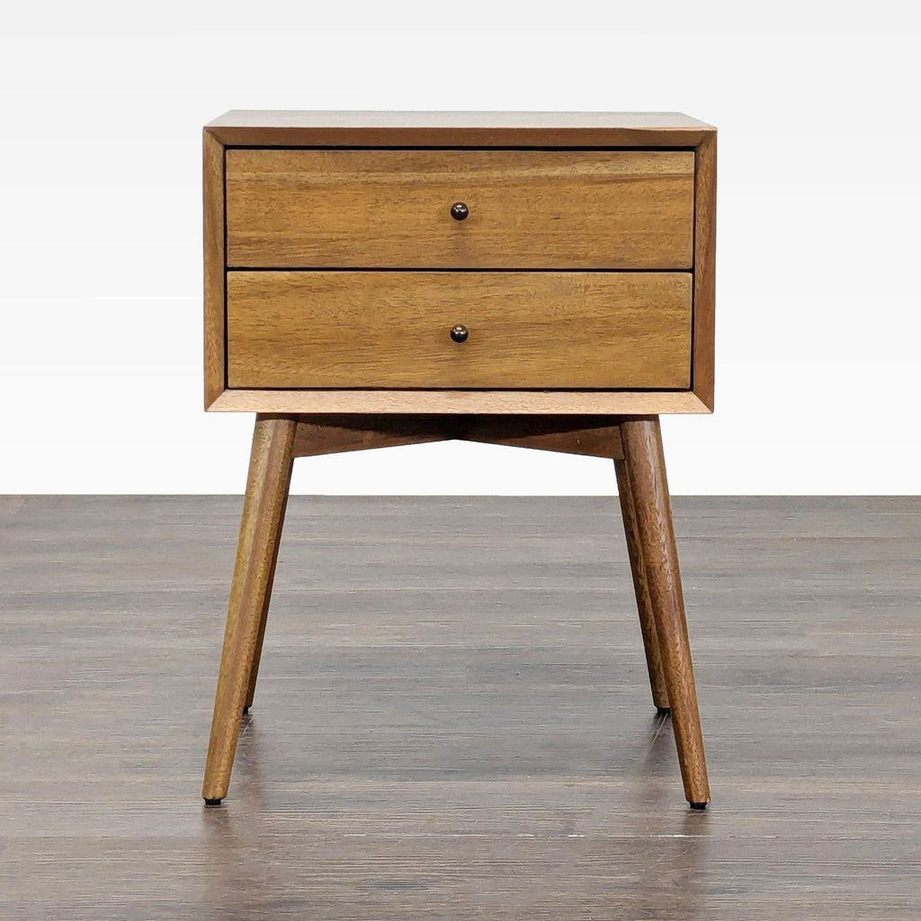 West Elm end table with tapered legs, beveled edges, and an angular base.  