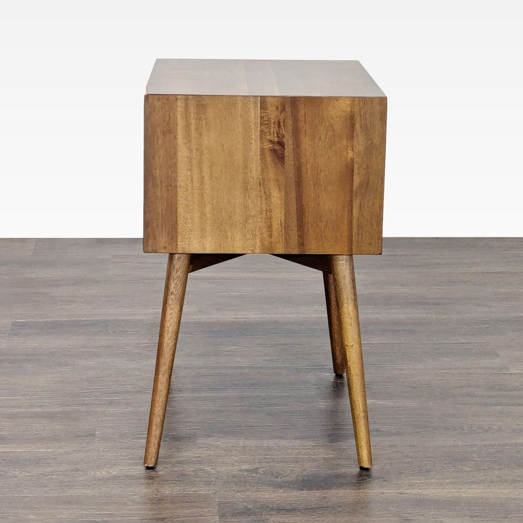 West Elm end table with angular base, tapered legs, and distinctive beveled edge detailing.