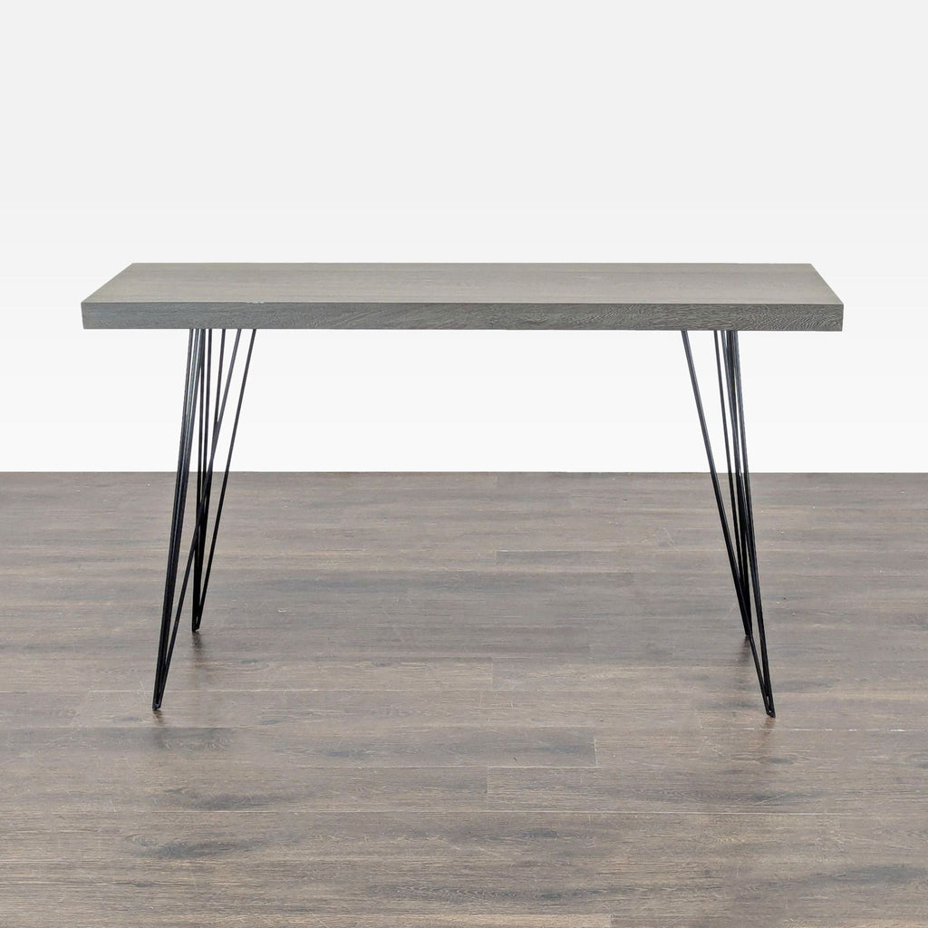 2. Minimalist console table featuring a rectangular gray wood surface and thin, angled black metal legs.