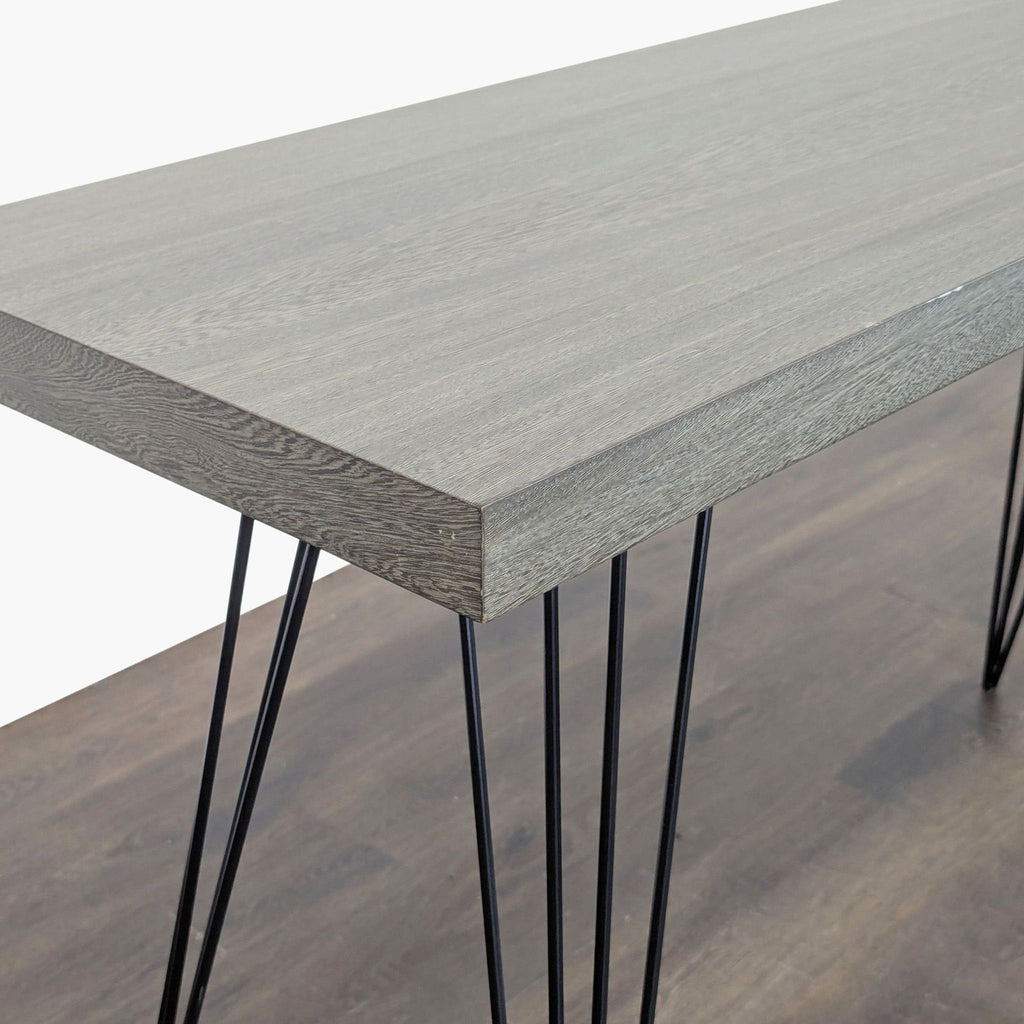 3. Close-up of a console table corner displaying textured gray wood top and stylish black hairpin metal legs.