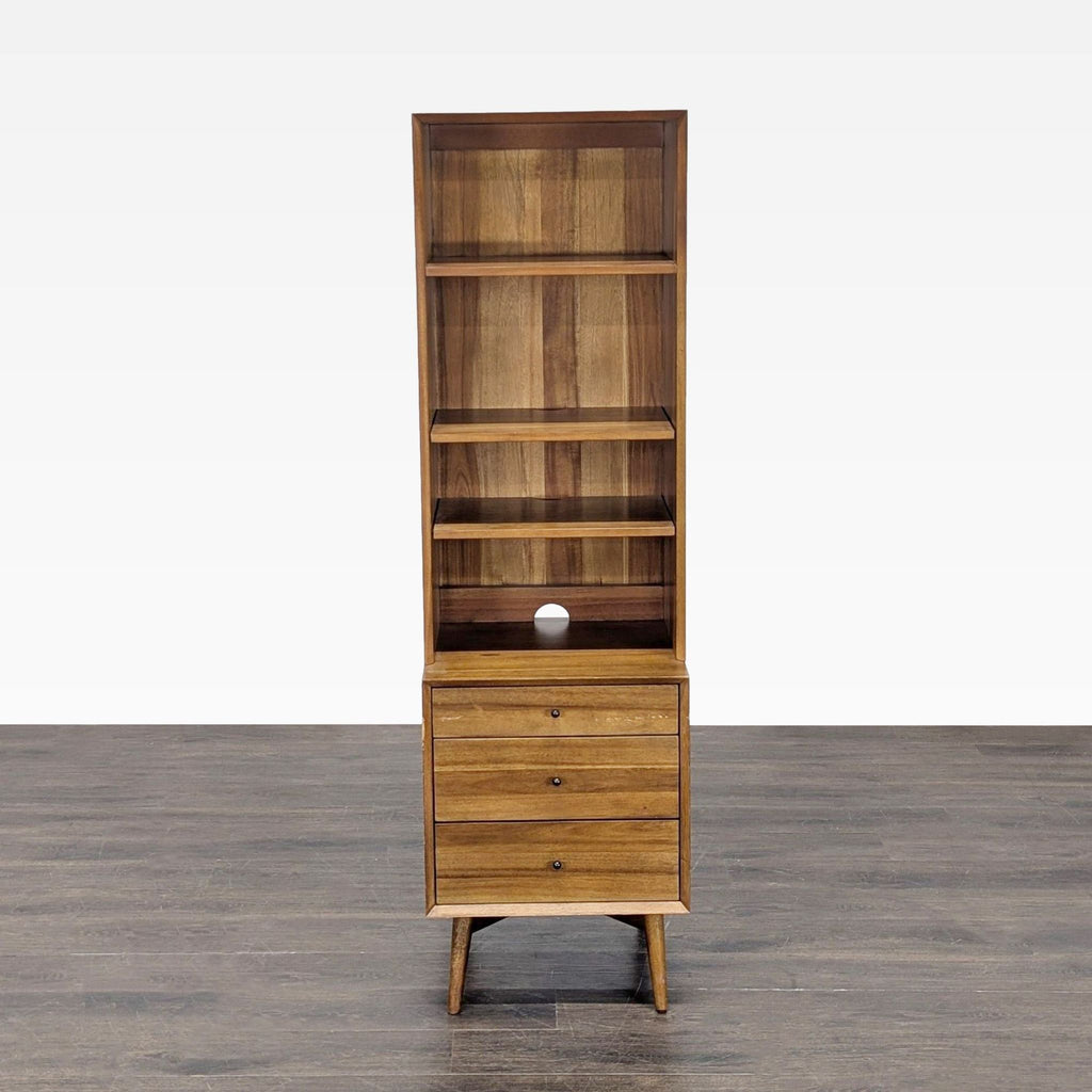 1. Front view of a tall West Elm bookshelf with three shelves and three drawers on mid-century legs.  