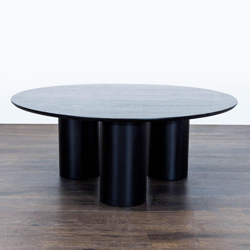 Ivy Bronx coffee table featuring a mix of solid and engineered wood with three blocky structural legs.