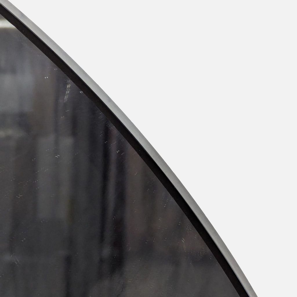 2. Detail of the curved edge of a Lindbyn mirror from IKEA, showing the slim frame design.