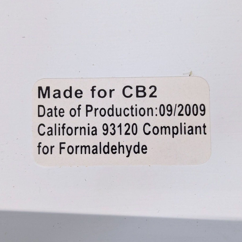 2. Close-up of a CB2 mirror's back label with production date and California formaldehyde compliance.