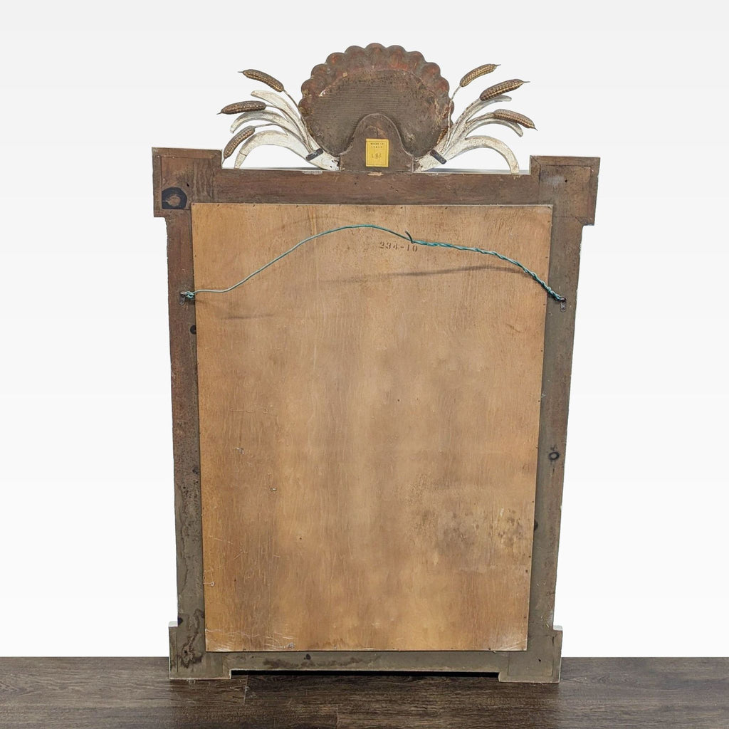 Mirror featuring detailed carvings of a shell, cattails, and draped swags on its frame.