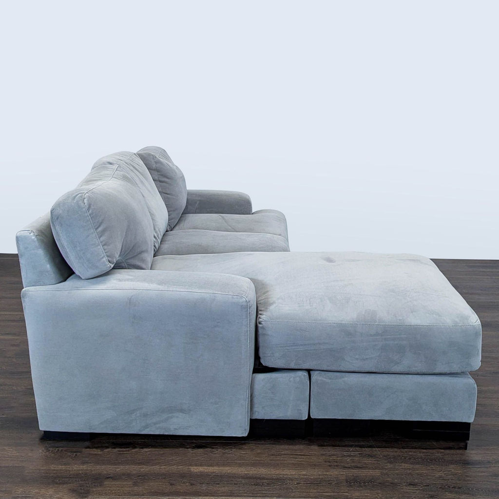 Living Spaces sectional in gray fabric with chaise lounge, wide armrests, and plush cushions, gently used and stylish.