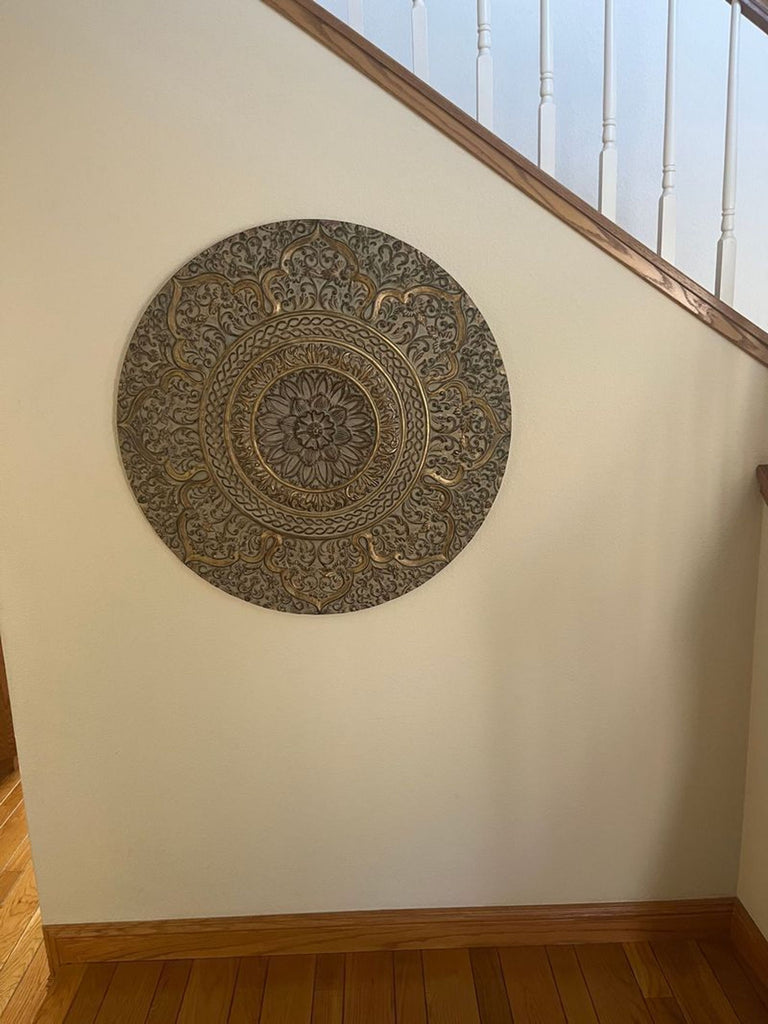 1. Decorative round Reperch wall art with intricate gold and grey floral pattern hanging by a staircase.