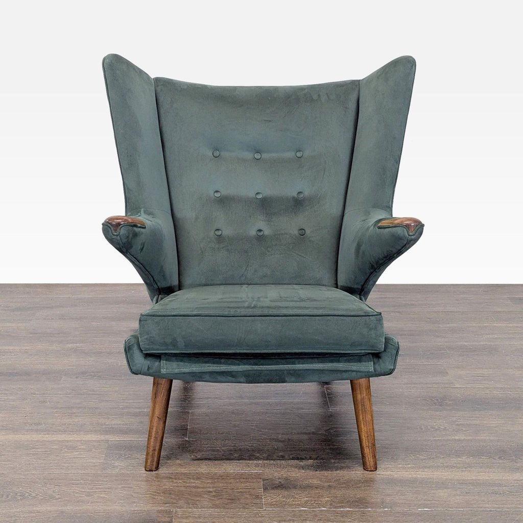 1. Hans Wegner lounge chair in dark green upholstery, high back, winged sides, and wooden legs, viewed from front.