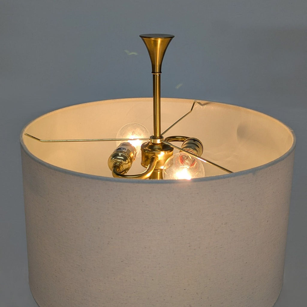 Elegant lighting fixture with brass base, white drum shade, and easy pull chains, ideal for living rooms or bedrooms.
