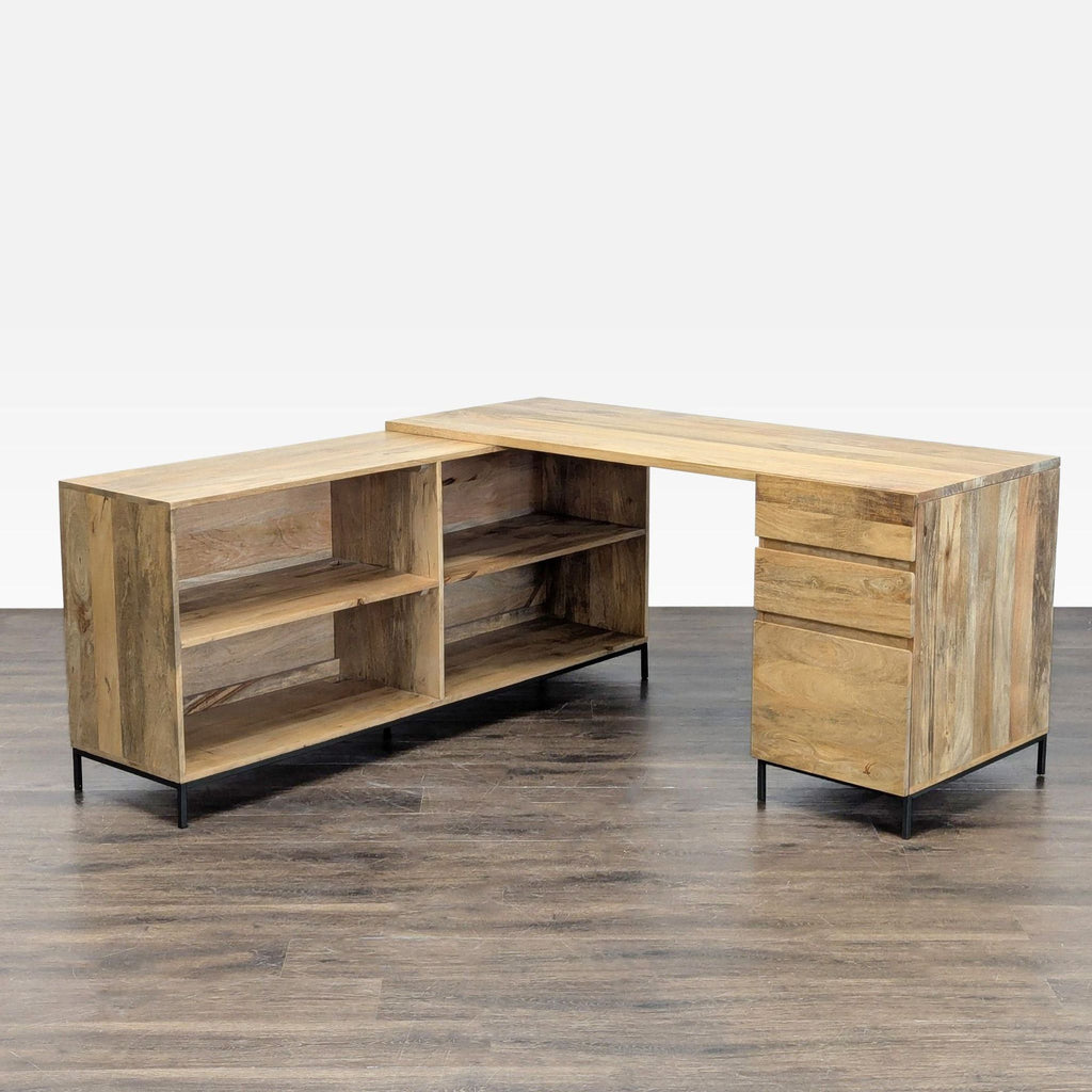West Elm L-shaped desk with natural wood finish, three drawers, and open shelves for office storage.