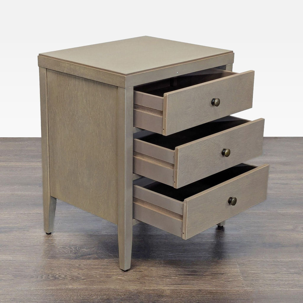 1. Crafted Home end table with three open drawers, wood finish, and simple metal knobs on a wood floor.
