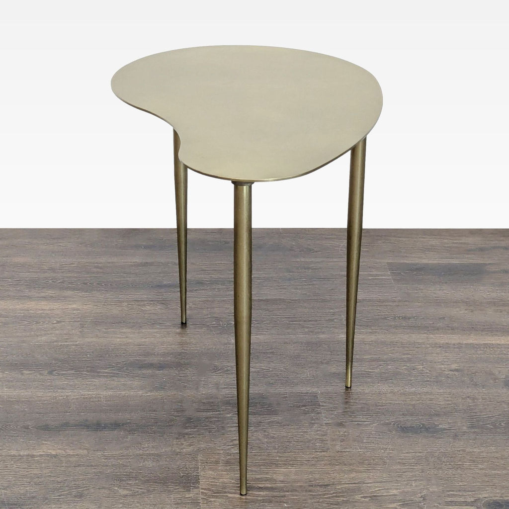 2. Contemporary console table featuring a curved metallic top and three tapered legs, viewed at an angle.