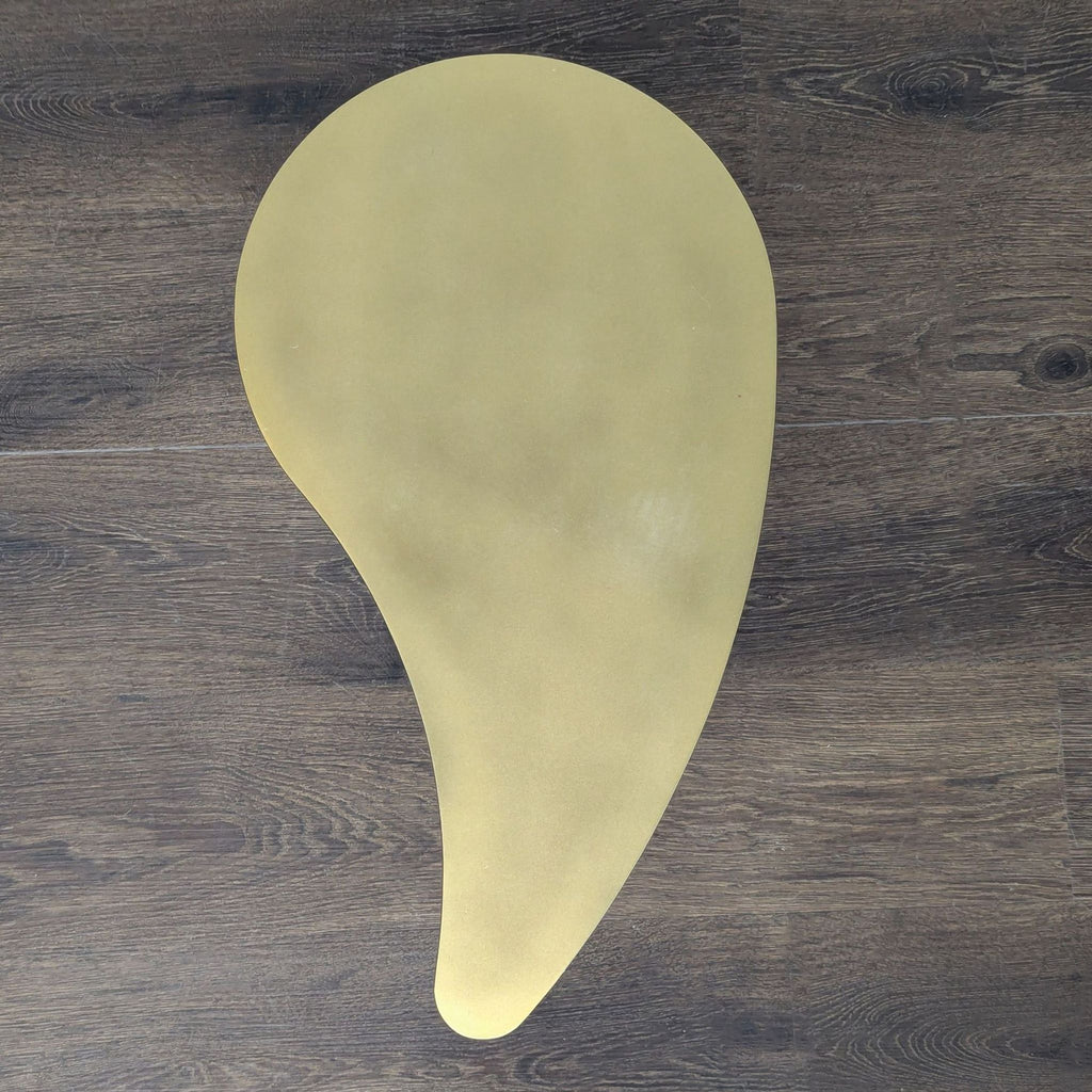 2. Overhead view of a gold, organically-shaped side or console table with rounded curves.  