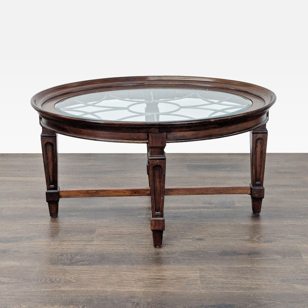 1. Round wooden coffee table with a glass top and decorative grid design, shown on a wooden floor.