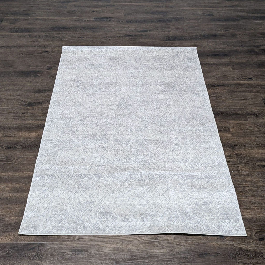 1. Light grey Calvin Klein rug with a subtle textured pattern, displayed on dark wood flooring.  