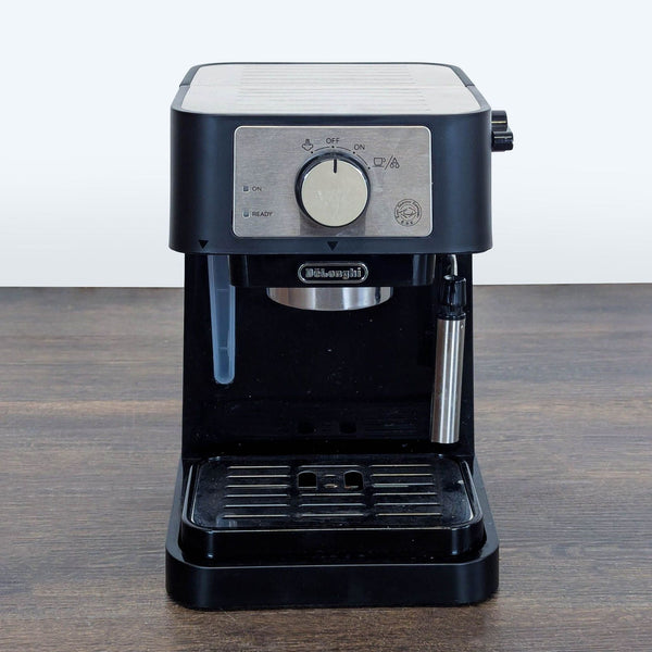 1. Front view of a compact DeLonghi coffee maker with a stainless steel steam wand and simple control knob.