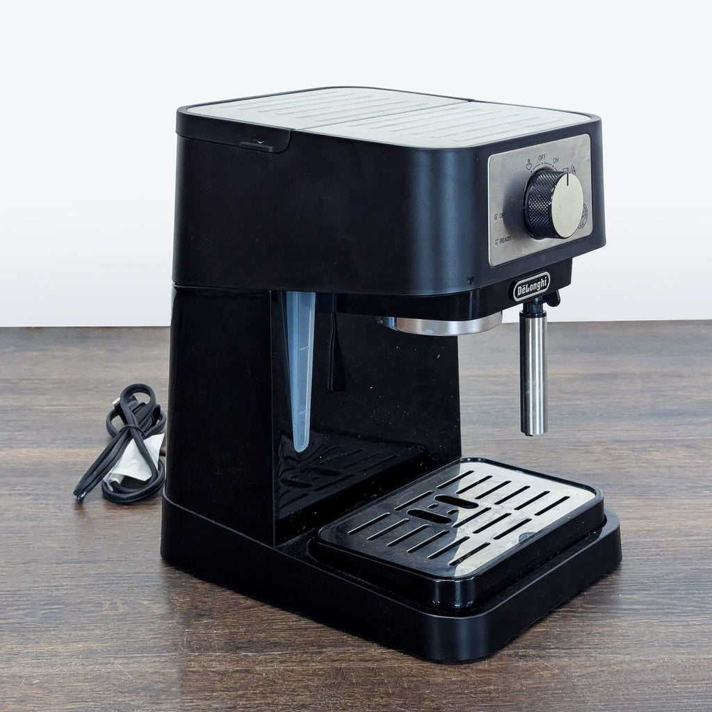 2. Angled side view of DeLonghi espresso and cappuccino maker with removable drip tray and black sleek design.