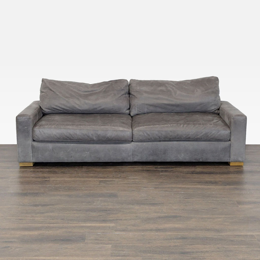 Front view of a modern gray leather Restoration Hardware 3-seat sofa with wide armrests and plush cushions.