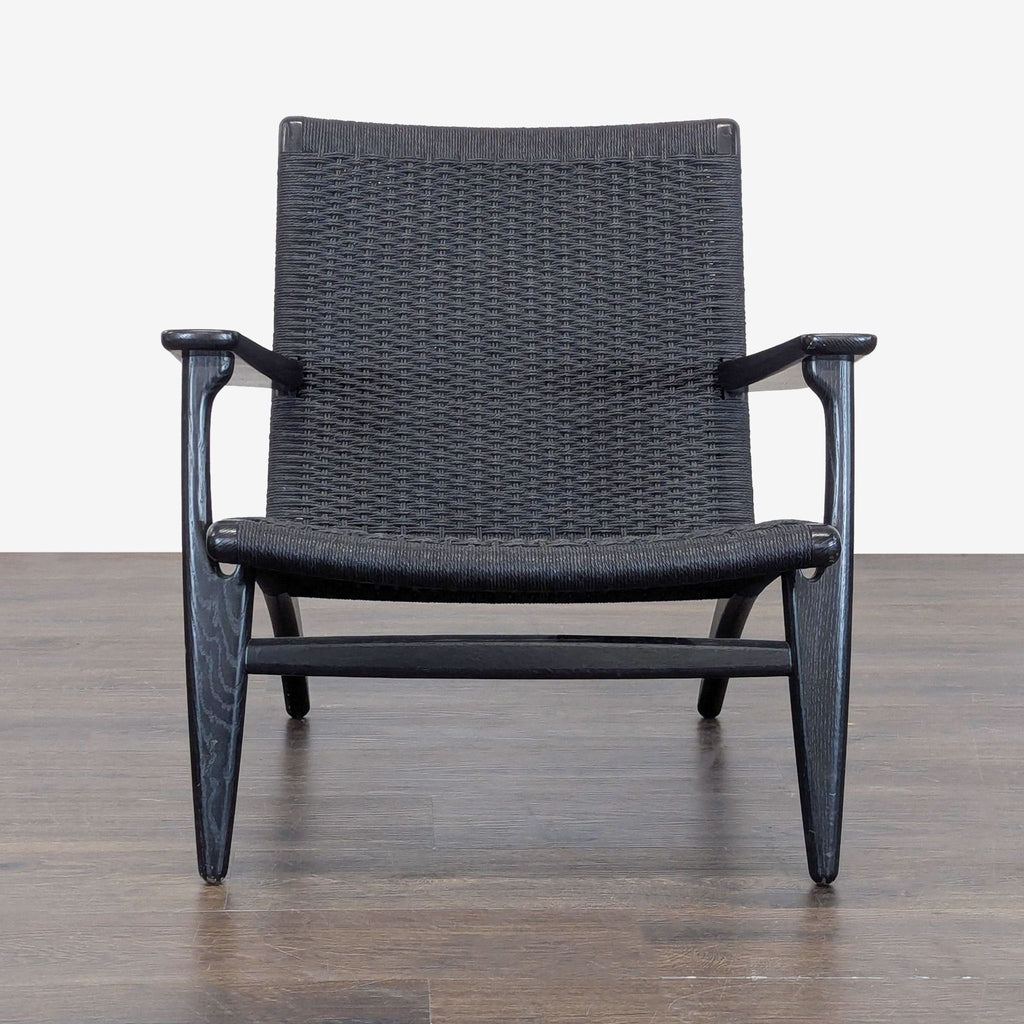 Black woven lounge chair with angled wooden frame and wide armrests by Carl Hansen & Son, modern minimalist style.