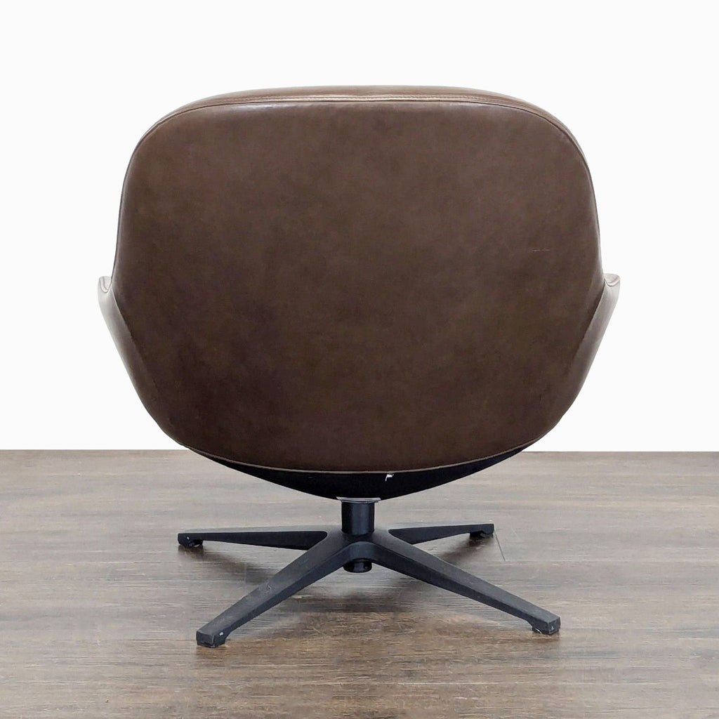 Back view of Article lounge chair, highlighting brown leather upholstery and contemporary black swivel base.
