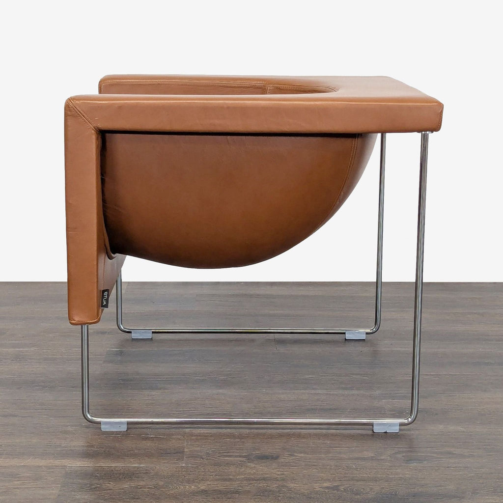 Modern STUA chair featuring smooth brown leather upholstery and shiny chrome legs, perfect for living spaces.