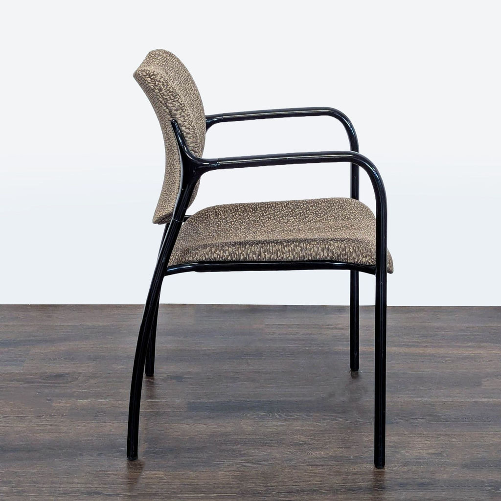 Padded office reception chair with patterned upholstery, sturdy frame, and armrests, made by Herman Miller.