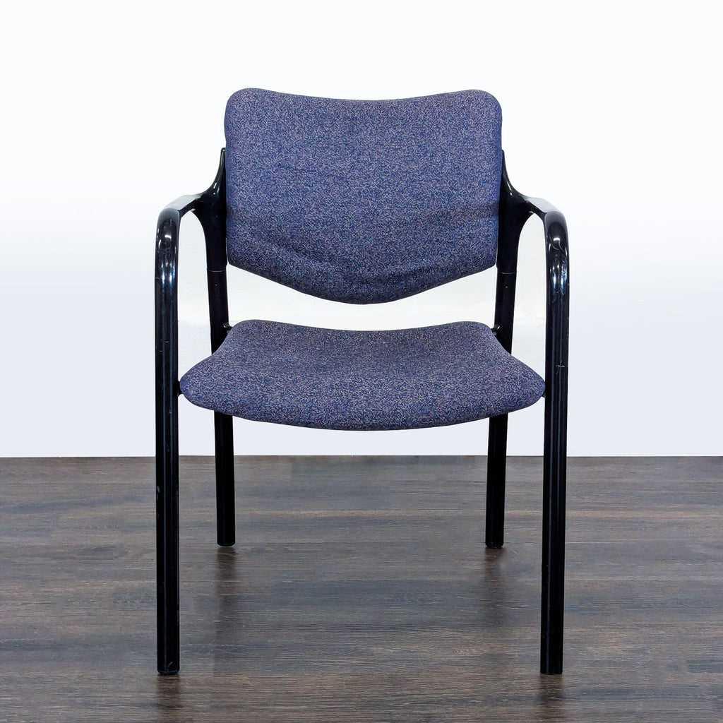 Front view of a Herman Miller guest chair with blue fabric seat, black metal arms, and legs on wood floor.