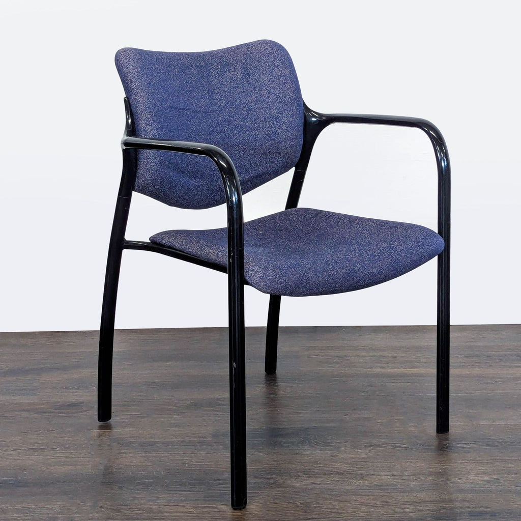 Angled view showing the padded blue fabric seat and back of a Herman Miller guest chair with sturdy black frame.