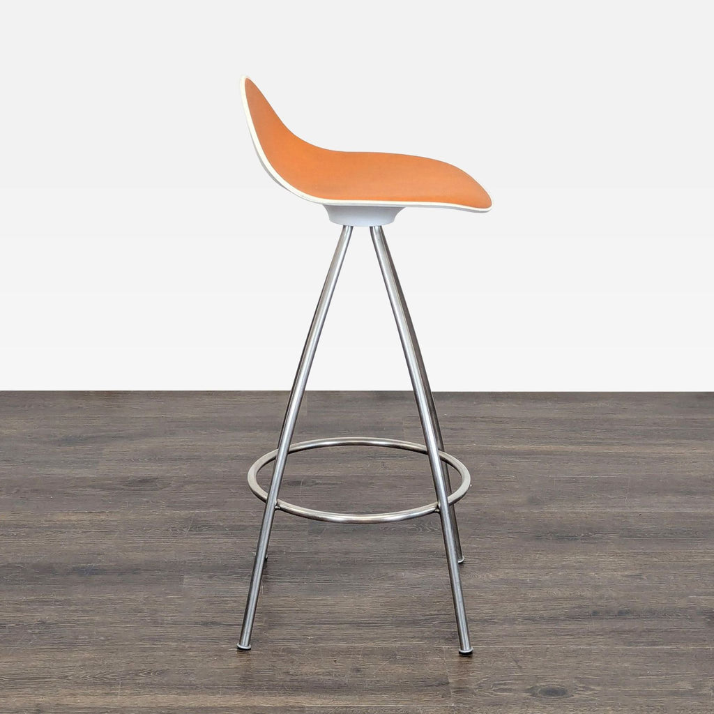 3. Side profile of an orange Stua stool featuring a contoured seat and sleek metal frame on a wooden floor.