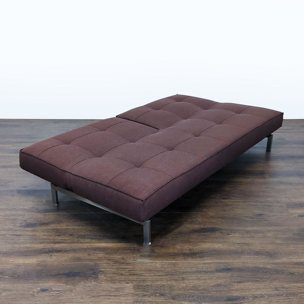 Sleek brown sofa by Innovation, features sturdy metal legs and easily transforms into a spacious sleeper.