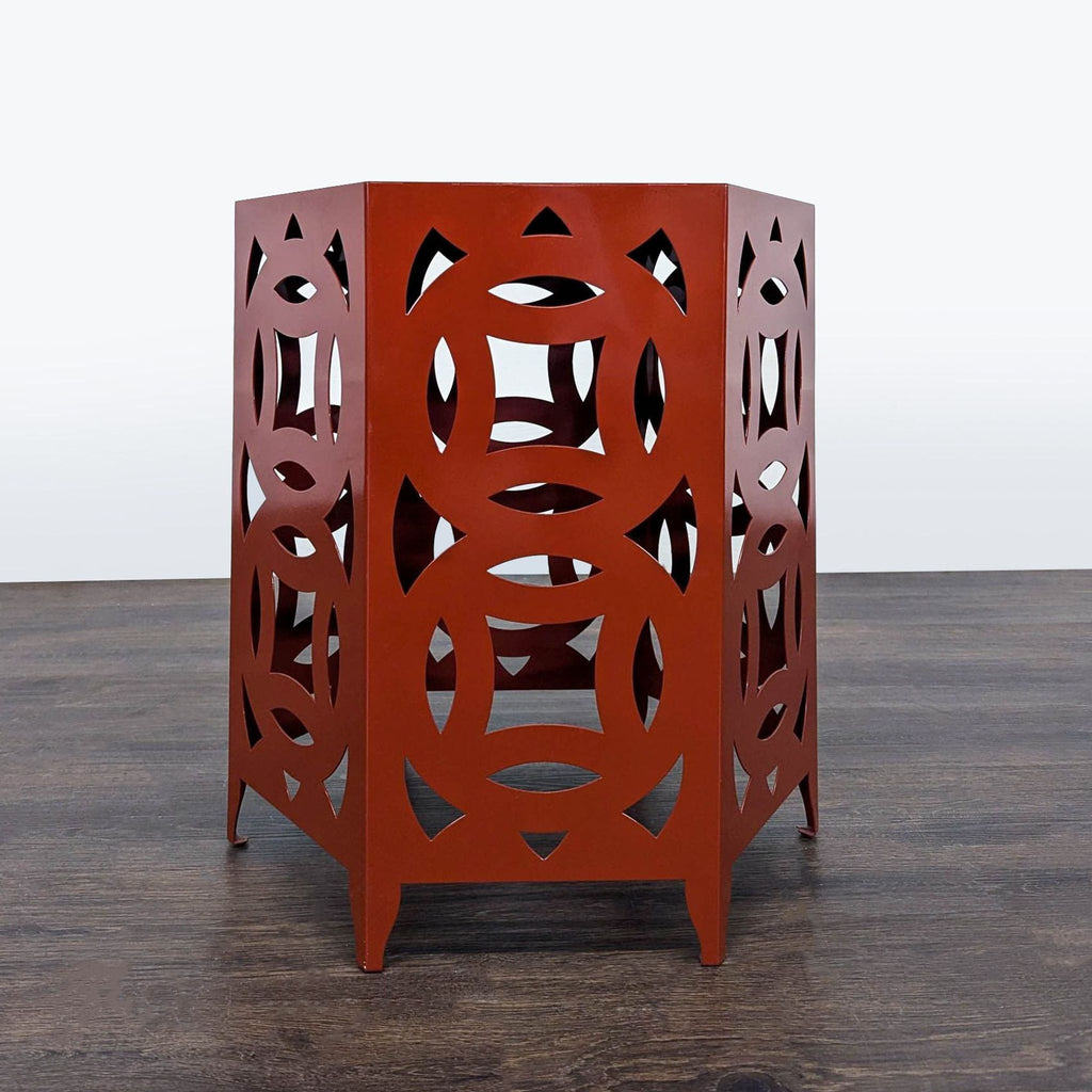 1. Hexagonal rust-red end table with geometric circular cutouts on all sides, placed on a wood floor.