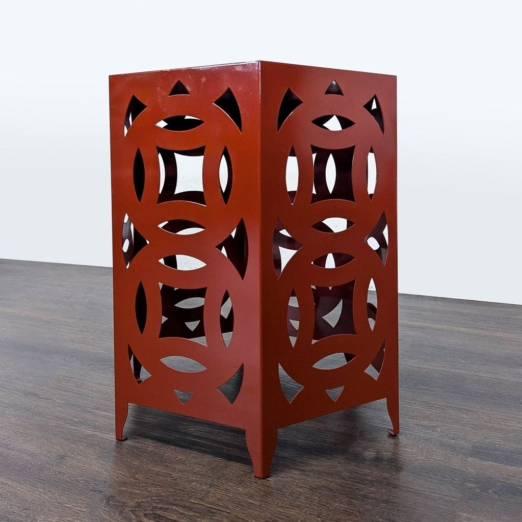 2. Modern metal end table in a burnt orange color featuring openwork circle patterns, set against a plain background.