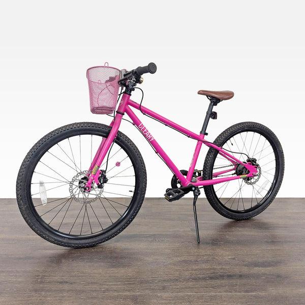 Pink Cleary 24-inch kids’ bike with brown saddle, front basket, disc brakes, and sturdy kickstand.