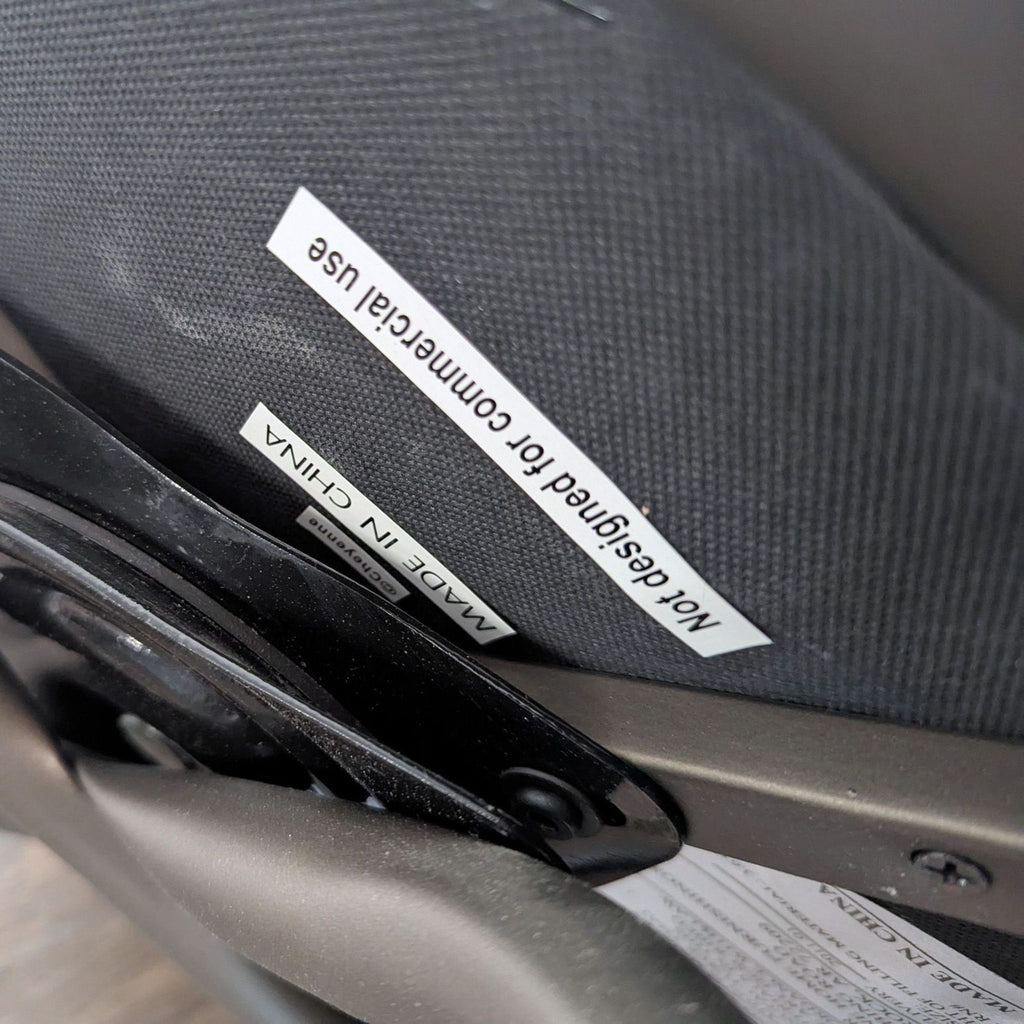 Close-up view of a stool's underside, showing labels reading "Made in China" and "Not designed for commercial use."  